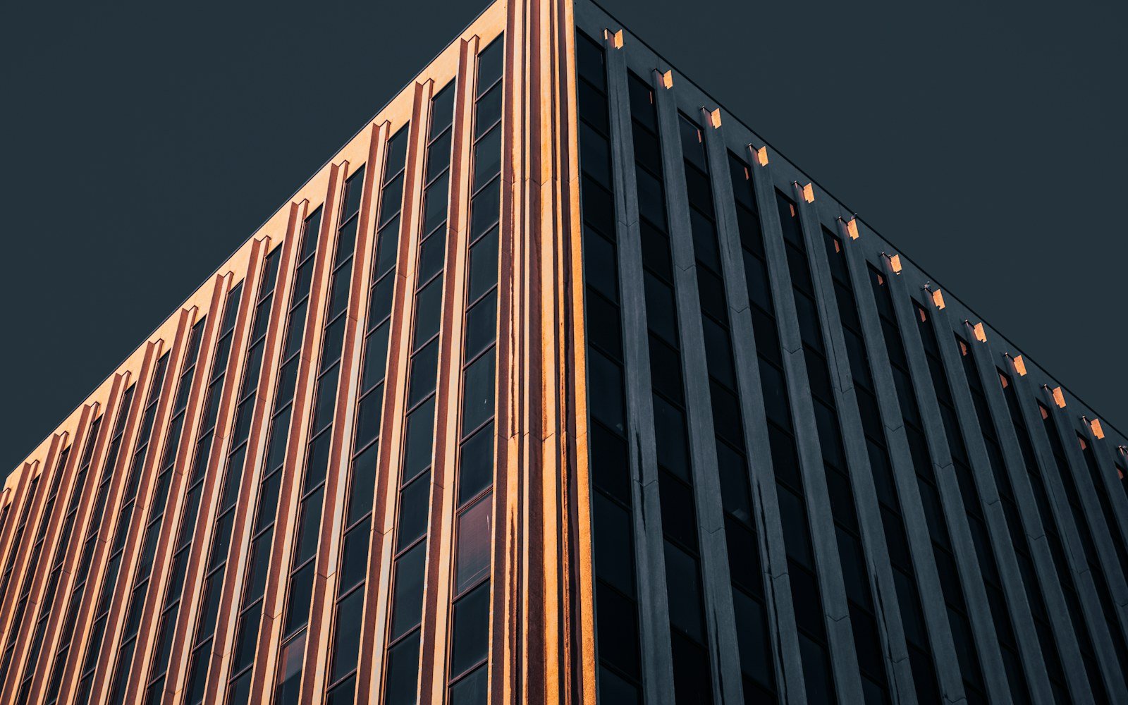 Fachada de edifício comercial em tons de cobre, vista em perspectiva